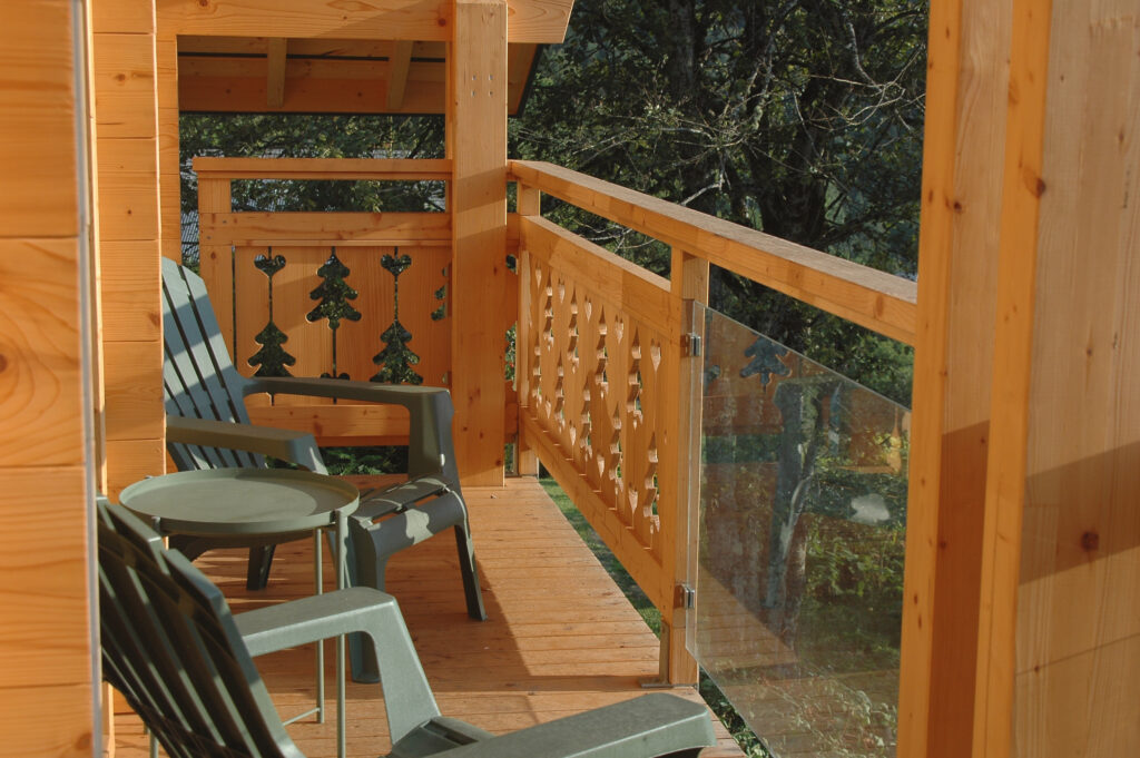 Balcon en bois du chalet La Godille, location en Val d'Arly, avec vue sur les Aravis.