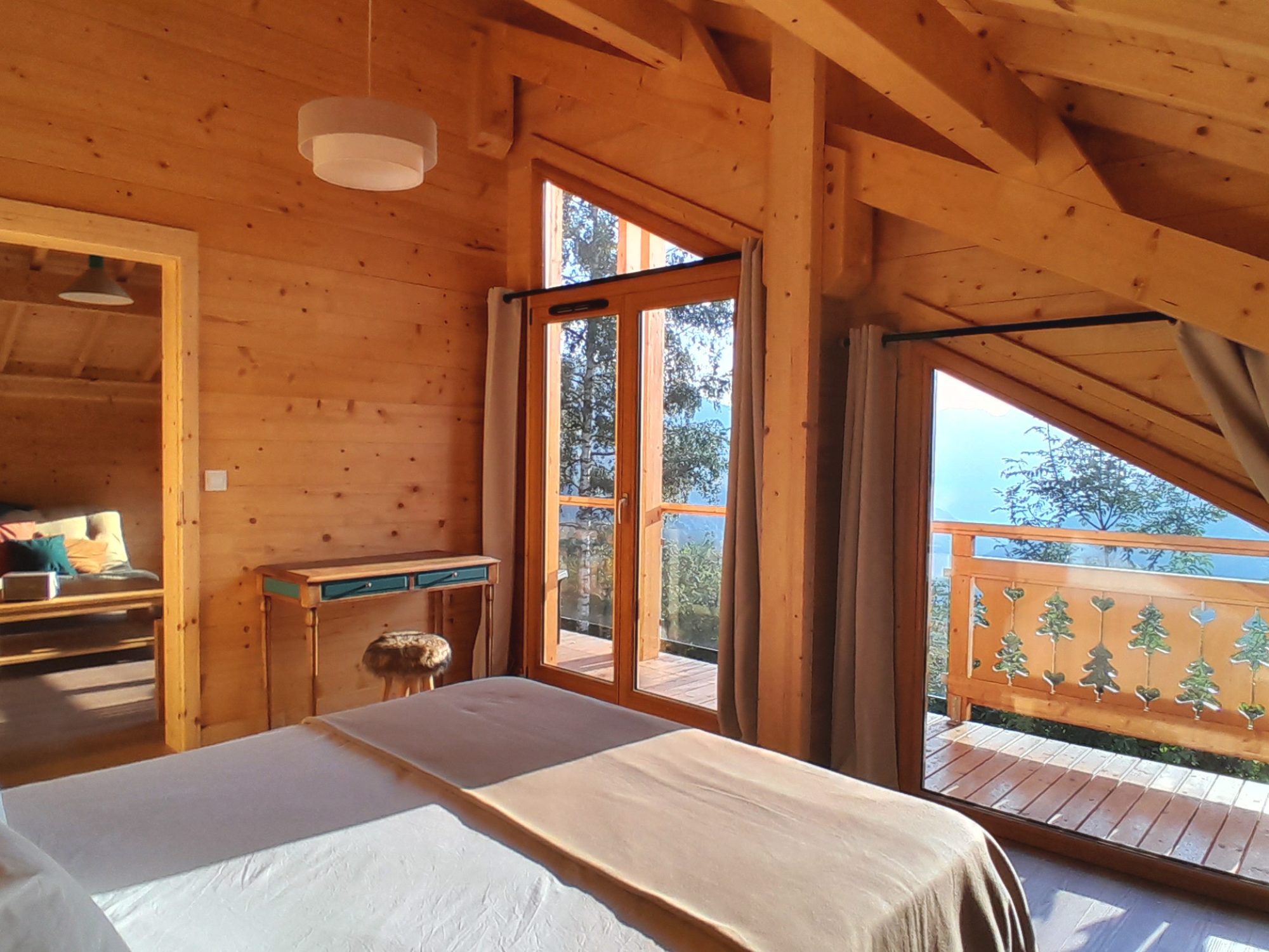 Chambre de l'étage du chalet La Godille, location à la semaine, avec balcon et vue sur les montagnes.