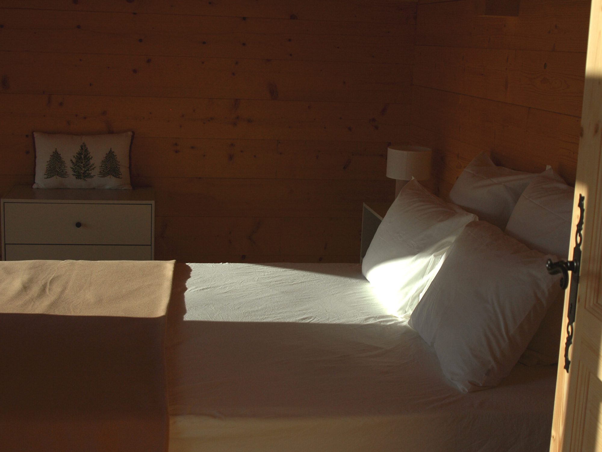 Chambre double de l'étage du chalet La Godille, location en Savoie. Lit confortable avec draps fournis.