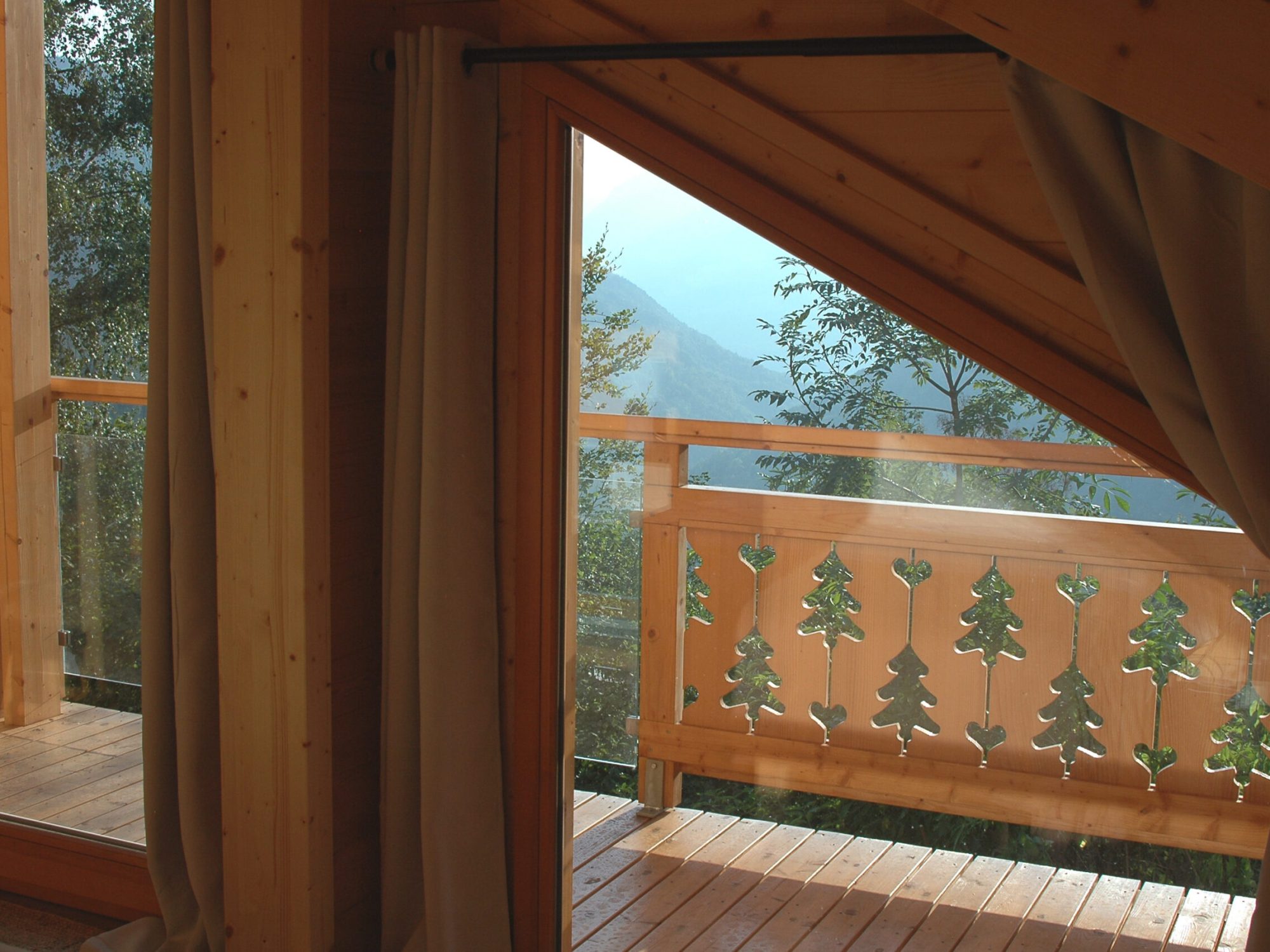 Chambre double de l'étage du chalet La Godille, location en Savoie. Vue sur les montagnes, chalet meublé tout en bois.